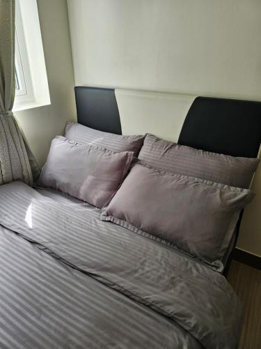 een bed met vier kussens in een kamer bij Trees Residence Condo in Manilla
