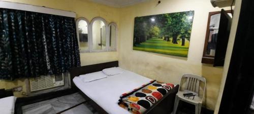 Habitación pequeña con cama y ventana en Khaja Hotel, en Calcuta