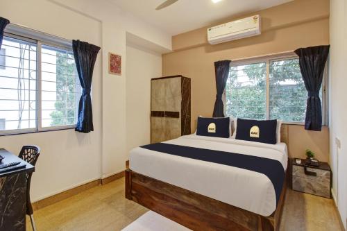 a bedroom with a large bed with blue pillows at Super Collection O Grey House in Pune