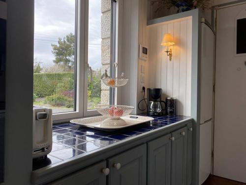 une cuisine avec un comptoir et une fenêtre dans l'établissement 758 - Charmante maison en pierre, à quelques minutes des plages du Guen et du centre d'Erquy, à Erquy