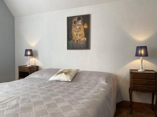 une chambre avec un lit et deux tables de nuit avec lampes dans l'établissement 758 - Charmante maison en pierre, à quelques minutes des plages du Guen et du centre d'Erquy, à Erquy