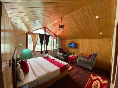 ein Schlafzimmer mit einem großen Bett in einem Zimmer in der Unterkunft Hotel Sky Mountain View by Hadimba Palace - Manali in Manali