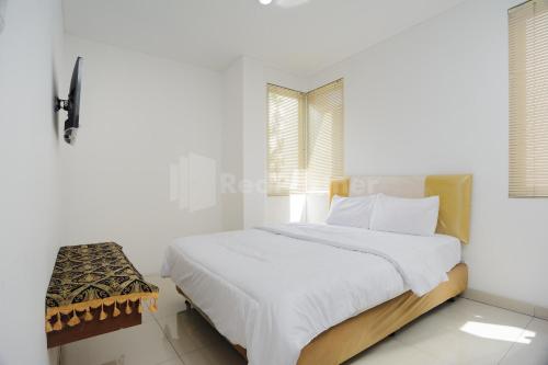 a white bedroom with a bed and a window at Green Residence 25 Syariah Karawaci RedPartner in Tangerang