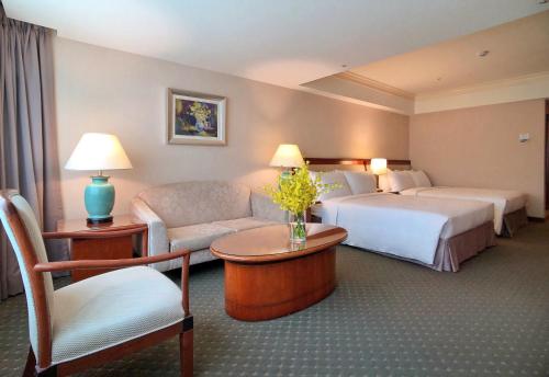 a hotel room with two beds and a couch at Evergreen Laurel Hotel - Taichung in Taichung