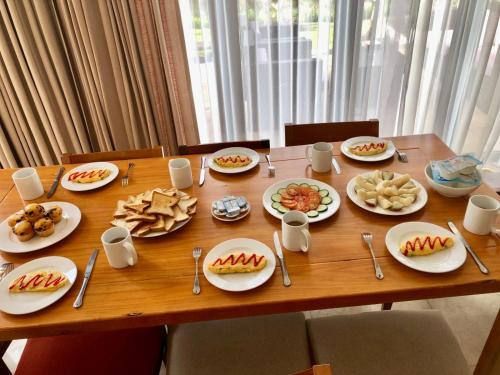 Una mesa de madera con platos de comida encima. en Danang Amazing Ocean Villas, en Da Nang