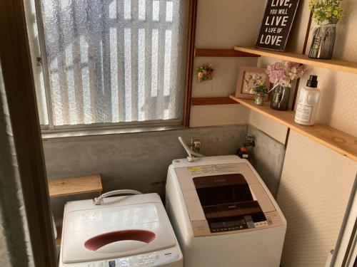 a small bathroom with a washing machine and a window at Classy Busshozan - Vacation STAY 15858 in Takamatsu