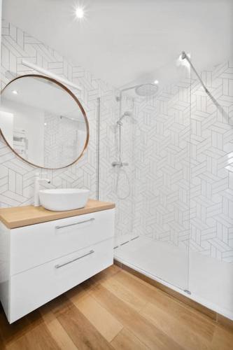 une salle de bain blanche avec un lavabo et un miroir dans l'établissement Spacious duplex with terraces, à Boulogne-Billancourt
