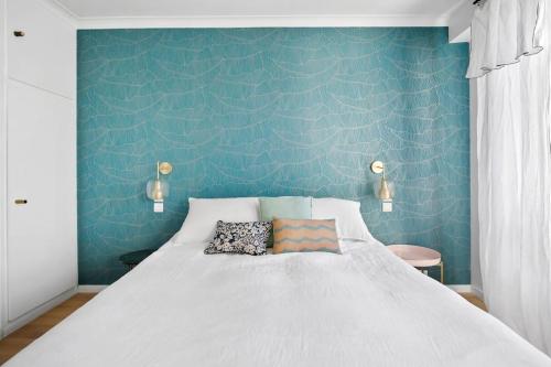 une chambre avec un grand lit avec un mur bleu dans l'établissement Spacious duplex with terraces, à Boulogne-Billancourt