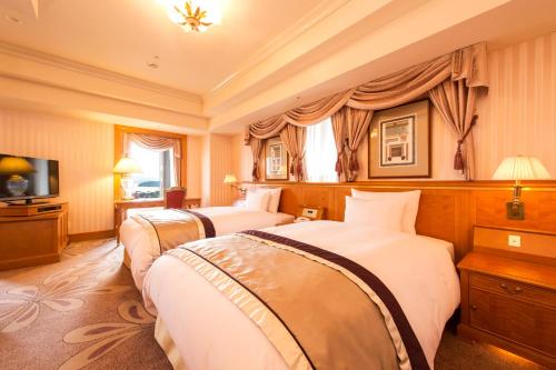 a hotel room with two beds and a television at Hotel Okura JR Huis Ten Bosch in Sasebo