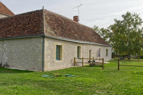 een oud stenen gebouw in een veld met gras bij The Plessis eco lodge at Port du Loup in Ferrière-Larçon