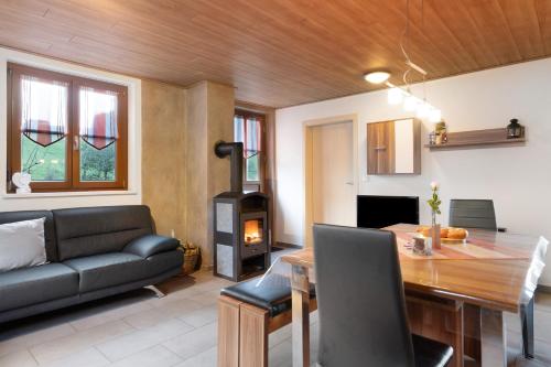 a living room with a couch and a table and a wood stove at Prinzbachhof in Mühlenbach