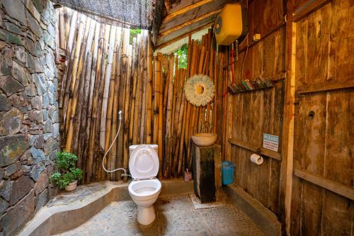 uma casa de banho com WC numa parede de madeira em Selini Hills em Labuan Bajo