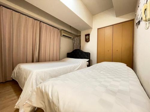 two beds in a small room withermottermottermott at A&C STAY Shinsaibashi in Osaka