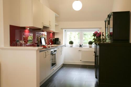 a kitchen with white cabinets and a black refrigerator at Ferienhaus Neudorf in Varel