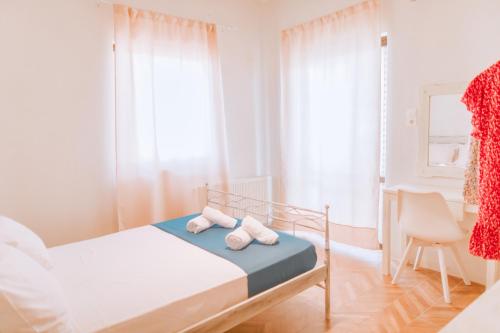 a white bedroom with a bed and a chair at Central house in Agios Nikolaos