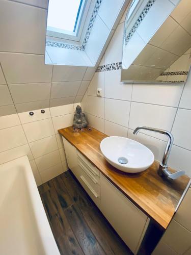 a bathroom with a sink and a mirror and a tub at Apartment SCHLEUSENTOR - Ferienwohnung Maisonette in Rostock