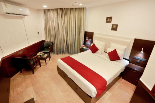 チェライ・ビーチにあるBlue Waters Cheraiの大きなベッドと椅子が備わるホテルルームです。