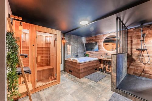 y baño con bañera y lavamanos. en Loft sous les colombages d'Alsace / Sauna / Jacuzzi / Netflix / Wifi en Drusenheim