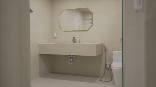 a bathroom with a white sink and a mirror at Island Stay in Jeju
