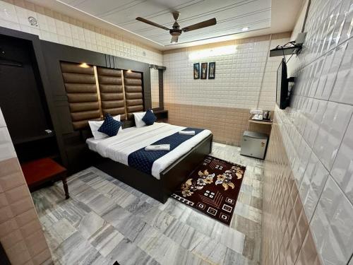1 dormitorio con 1 cama y TV en Hotel Sheela, 100m from Taj Mahal, en Agra