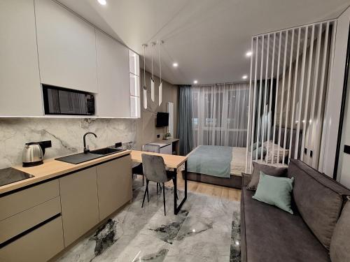 a kitchen and a living room with a bed at Сучасні апартаменти в новобудові in Lviv