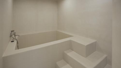 a white room with stairs in the corner at Island Stay in Jeju