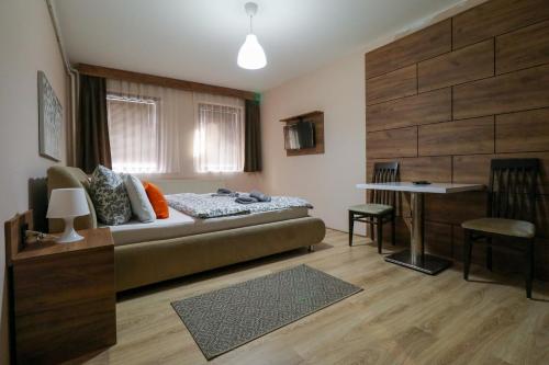 a living room with a bed and a table at Studio Apartments Maksimović in Niš