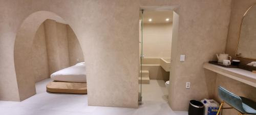 a bedroom with a bed and a glass shower at Island Stay in Jeju
