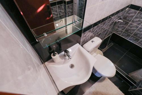 a bathroom with a white sink and a toilet at Studio Apartments Maksimović in Niš