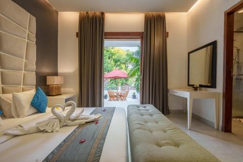 a hotel room with a bed with swans on it at Villa Orange Seminyak in Seminyak