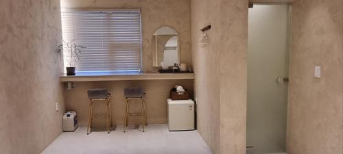 a kitchen with three stools and a counter with a sink at Island Stay in Jeju