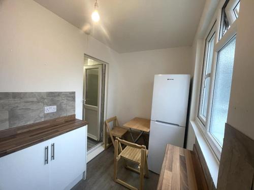 a kitchen with a refrigerator and a table and a table and a chair at Adorable 1-bedroom entire place with free parking in Cambridge