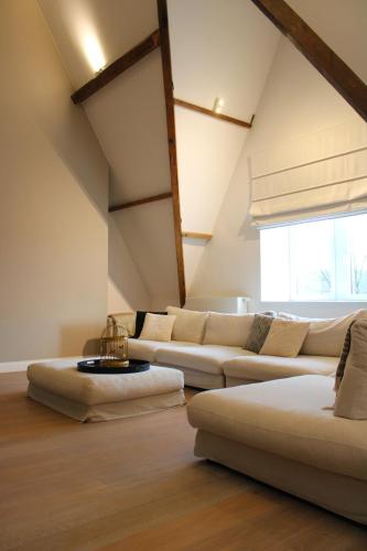 a living room with two white couches and a window at Un Toit sur les Monts in Esneux