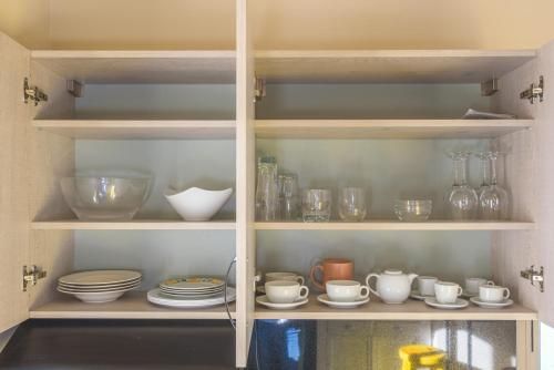 a cupboard filled with bowls and plates and other items at 961 Station Apartments in Mar Mikhael in Beirut