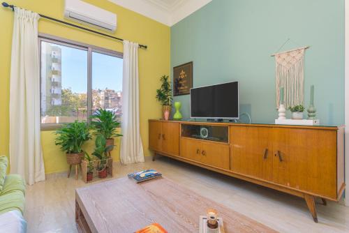 a living room with a flat screen tv on a dresser at 961 Station Apartments in Mar Mikhael in Beirut