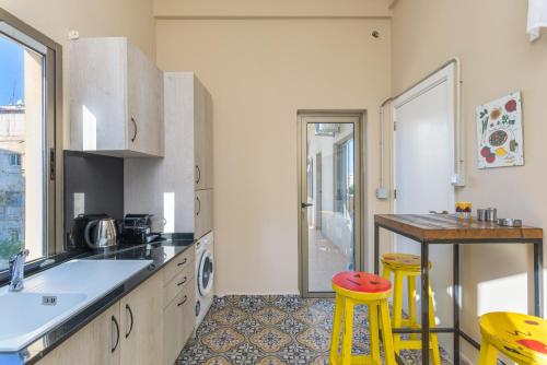 a kitchen with a table and two yellow stools at 961 Station Apartments in Mar Mikhael in Beirut