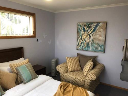 a room with a bed and a couch and a window at Sunshine Apartment in Austins Ferry