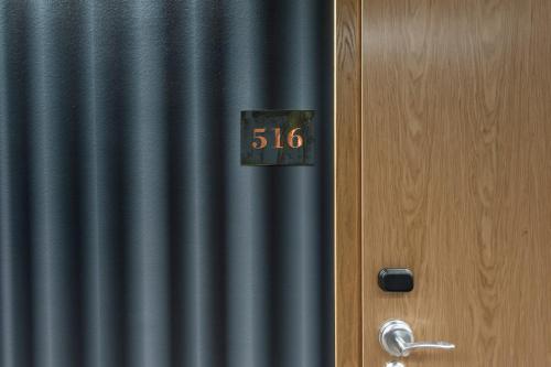 a clock on a door next to a curtain at Apartments By Ligula, Hammarby Sjöstad in Stockholm