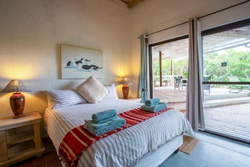 1 dormitorio con 1 cama con toallas en Kangela Estate 14, en Ponta Malangane