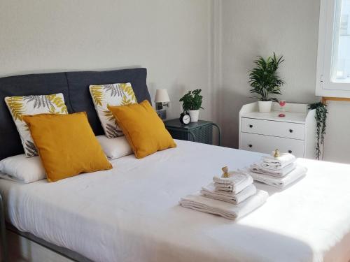 una camera da letto con un letto bianco con cuscini gialli di Dehesa Centro a Soria