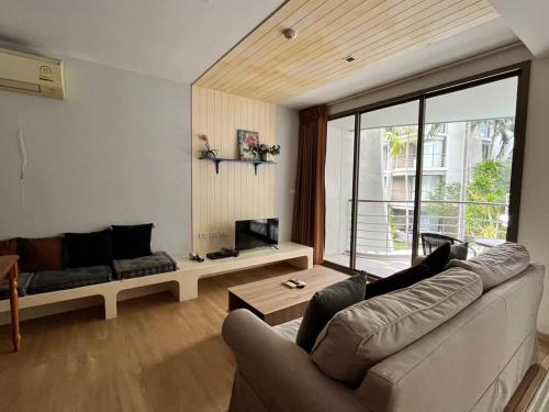 Una sala de estar con un sofá y un televisor. en BanSanKram by Patsara, en Cha Am