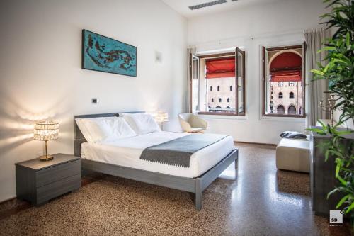 ein Schlafzimmer mit einem Bett, einem Stuhl und einem Fenster in der Unterkunft Urbanicooh Paracelso - Piazza Maggiore View in Bologna
