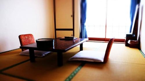 a living room with a table and two chairs at Hotel Sumire ふぐ料理を愉しむ料理宿 in Shimonoseki