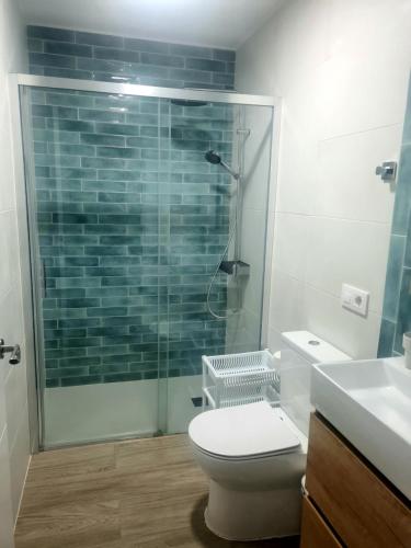 a bathroom with a toilet and a glass shower at Apartamento Atlanterra Bajo in Zahara de los Atunes
