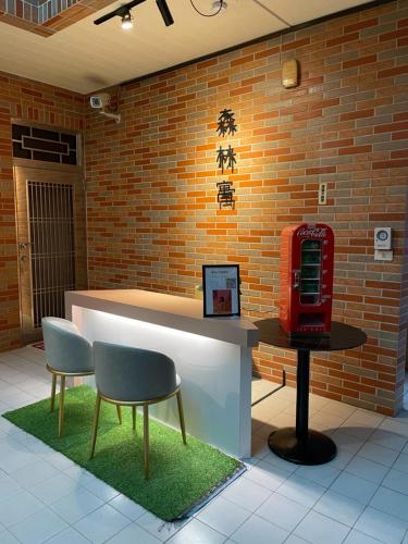 a lobby with a red telephone booth and two chairs at 森林寓 in Minxiong