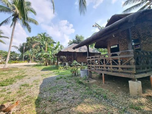 a house with a thatched roof and a yard at California Breeze Campsite in Indang