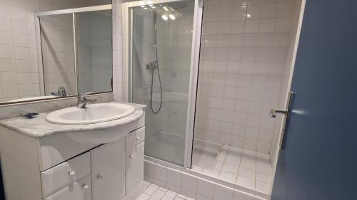 une salle de bain blanche avec un lavabo et une douche dans l'établissement 5017 Tennis Village 602, au Cap d'Agde