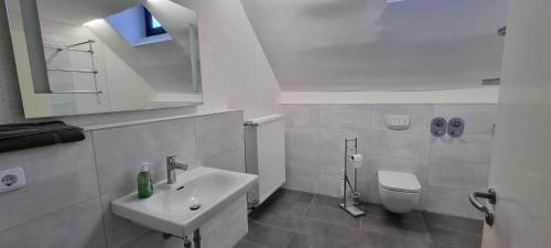 a white bathroom with a sink and a toilet at Gasthaus Winkelvoß in Einbeck