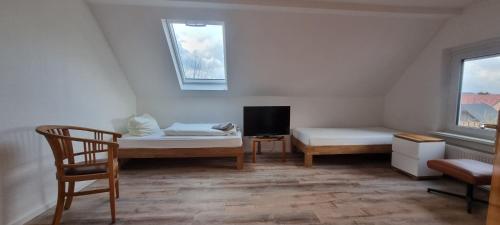 アインベックにあるGasthaus Winkelvoßのベッド2台、椅子、窓が備わる客室です。