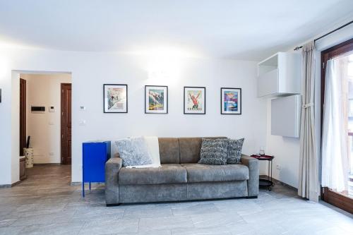 una sala de estar con sofá y algunas fotos en la pared en Casa dei Ciliegi, en Morgex